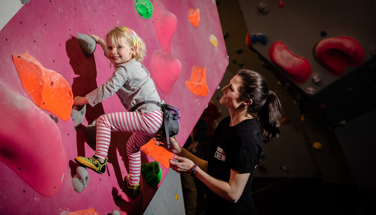 Little girl climbing with crew member